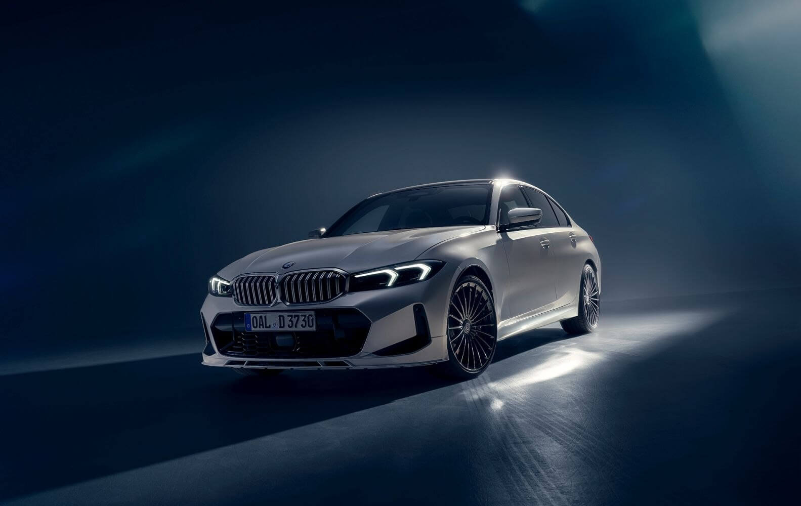 Alpina D3 sedan based on the BMW 3 Series (G20 LCI), photographed in a studio-style scene with modern LED lighting and multi-spoke Alpina wheels