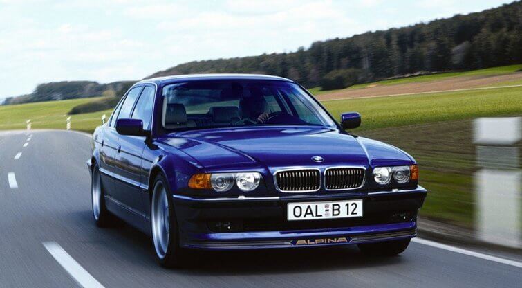 Alpina B12 based on the BMW 7 Series (E38), photographed driving on a public road with Alpina front spoiler and classic proportions