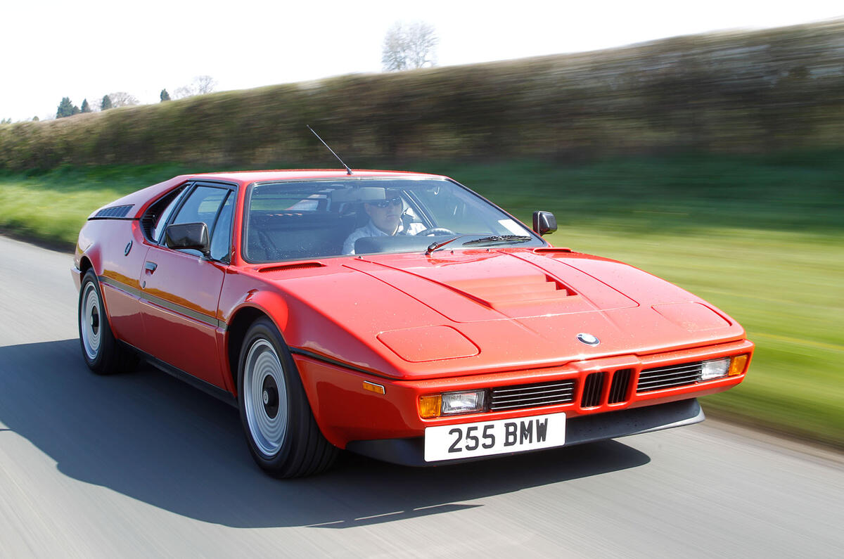 BMW M1 Procar mid-engine sports car in red, front three-quarter studio view showing wedge design.